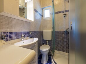 Ein Badezimmer mit Waschbecken, Toilette und einer Duschkabine.