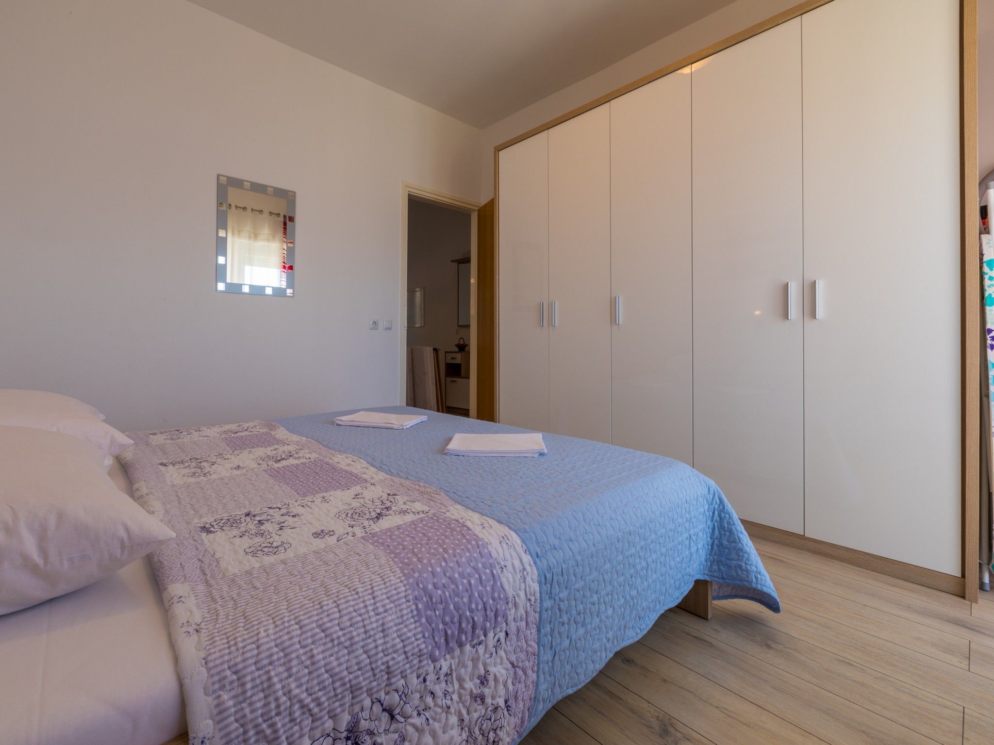 A bedroom with a bed, a wardrobe, and a small window.