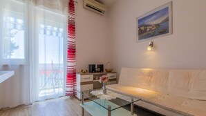 A living room with a glass coffee table, white sofa, and a painting on the wall. - House Blanka (Dramalj)