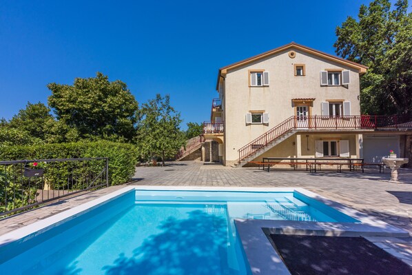A two-story building with a swimming pool in front.