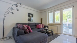 A modern living room with a grey sofa, a glass coffee table, and a floor lamp. - House Moderna 2 (Crikvenica)