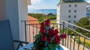 A balcony with a view of a building and the sea. - Apartments Seper (Crikvenica)