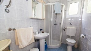 Une salle de bain équipée d’un lavabo, de toilettes et d’une douche.