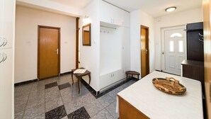 Una habitación de hotel con un armario grande, una mesita con bandeja y un espejo.