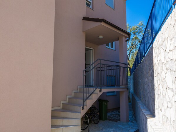 A multi-story building with a staircase leading to a balcony.
