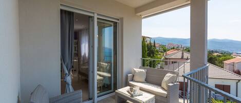 A balcony with wicker furniture, a sliding glass door, and a view of the landscape.