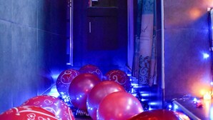 A hallway with red and pink heart-shaped balloons, a mirror reflecting a red heart decoration, and a patterned curtain. - The Hummingbird Villa Luxury Suite- Vacation Rental Beach Resort Villa in Mayaro (Guayaguayare)