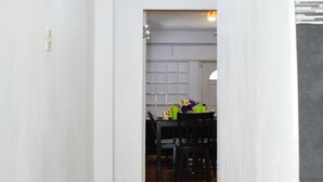 A narrow hallway with wooden flooring leading to a dining area with a table and chairs. - The Hummingbird Villa Luxury Suite- Vacation Rental Beach Resort Villa in Mayaro (Guayaguayare)