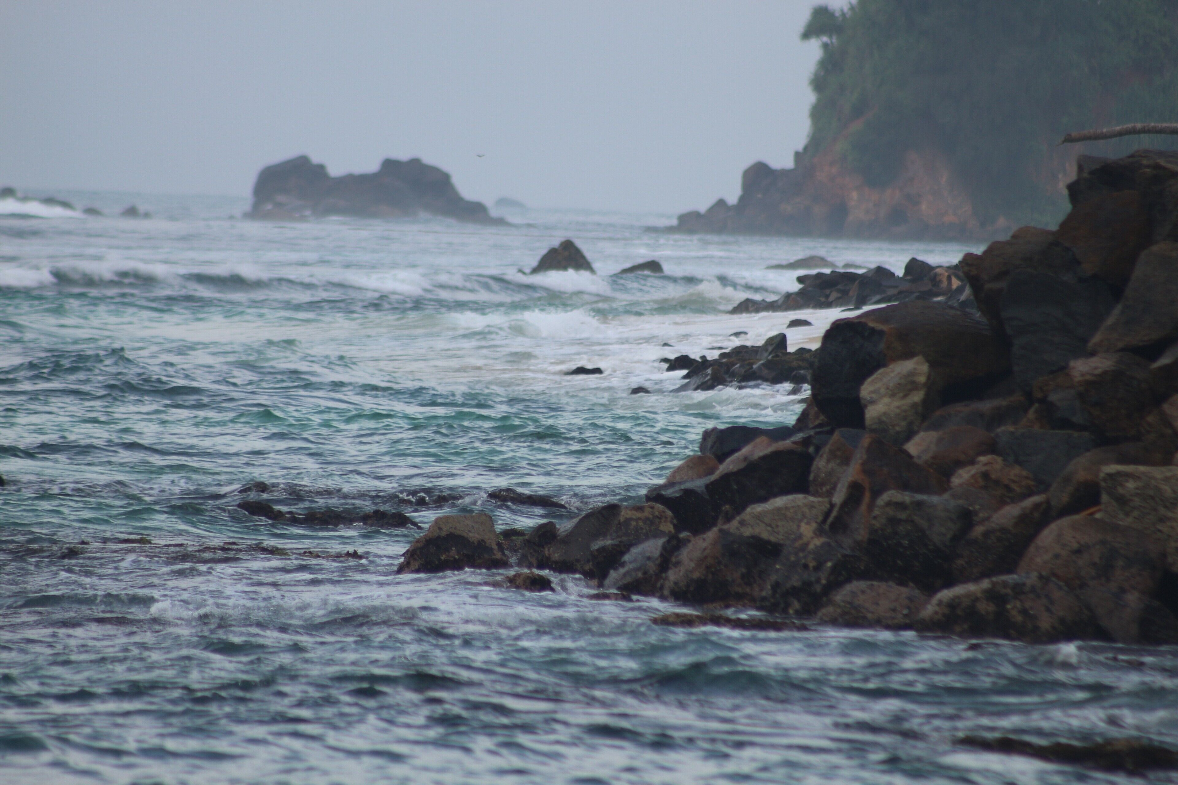 A rocky shoreline with waves crashing against the rocks.
