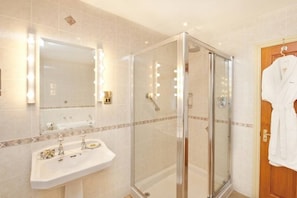Bathroom features a glass-enclosed shower, vanity with sink, and mirror.