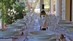 Una mesa preparada para una comida, con copas de vino, platos y cubiertos.