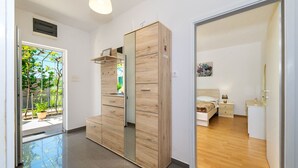 Un dormitorio moderno con un armario de madera, una cama, mesitas de noche y vistas al exterior.