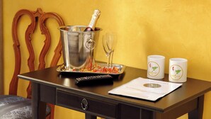 A table with a champagne bottle, two glasses, a remote control, and two mugs. - Domus Gallo B&B (Rome)