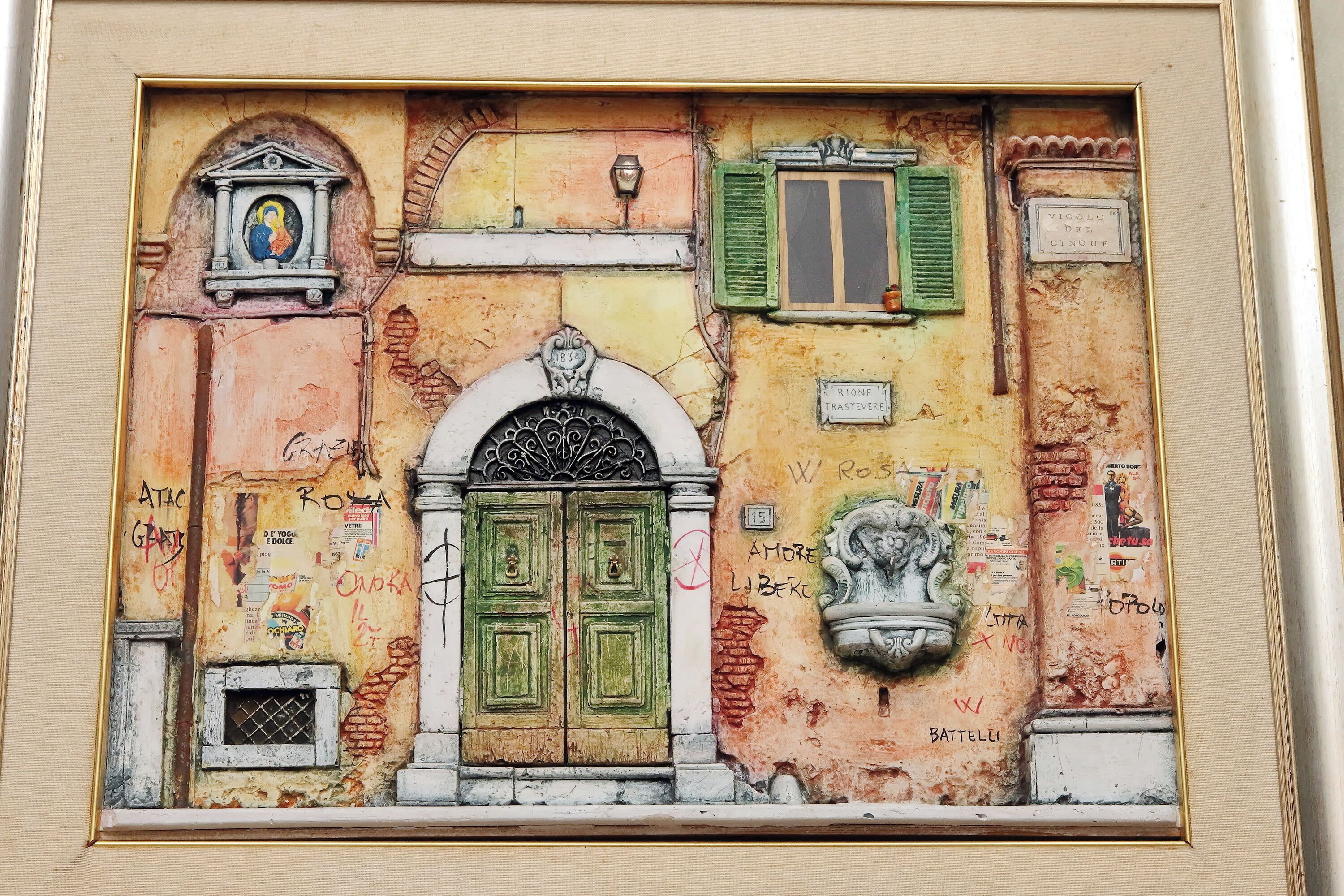 A framed artwork depicting a building facade with a green door, a window, and a plaque.