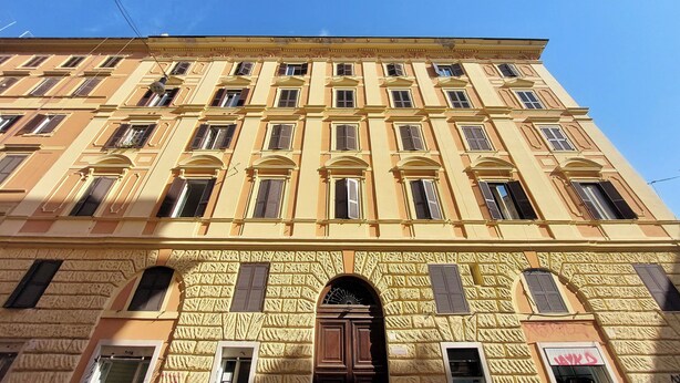 A multi-story building with a symmetrical facade, large windows, and a central entrance with a decorative archway. - Domus Gallo B&B (Rome)