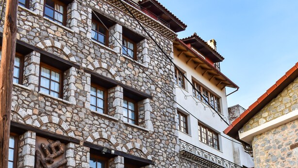 Un edificio de piedra con varias ventanas y un garaje.