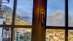 Una ventana con vistas a un paisaje montañoso y un pueblo en la falda.