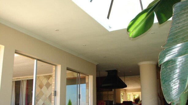 A spacious indoor area with a large window, a pool, and a dining area. - Shirleys Place (Cape Town)