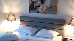 A bedroom with a bed, two bedside tables, a nightstand, a lamp, and a wall art piece. - WOODEN HOUSE, chalet style (Lontzen)