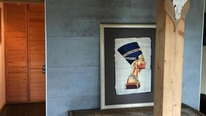 A room with a wooden chest, a framed picture on the wall, and a wooden door. - WOODEN HOUSE, chalet style (Lontzen)