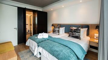 Una habitación de hotel moderna con una cama grande, dos mesitas de noche y un armario.