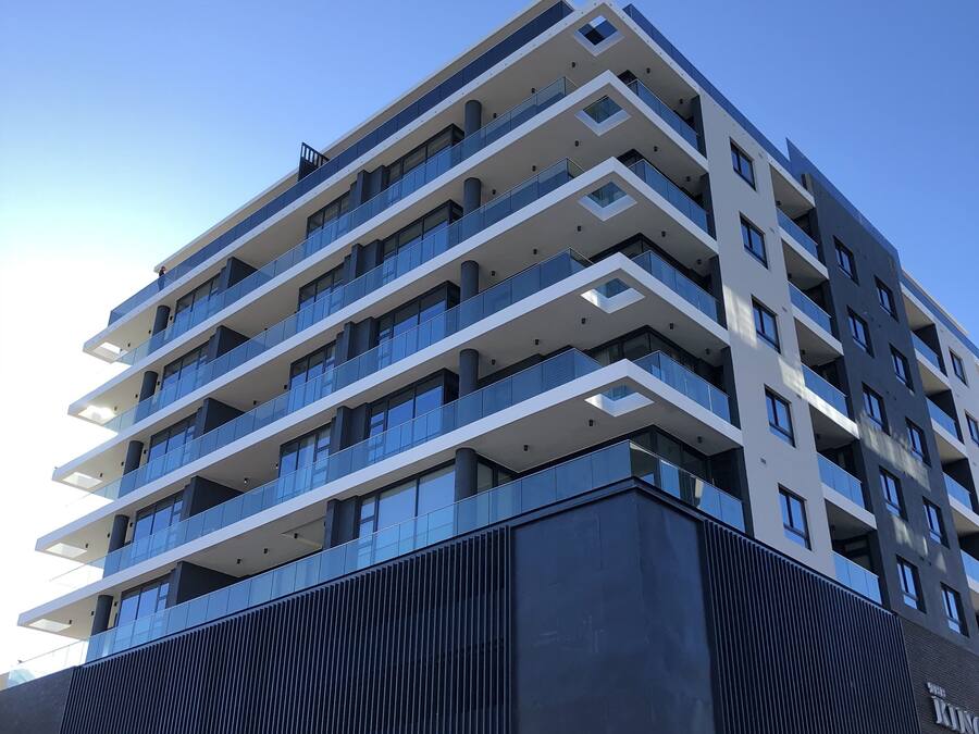 A multi-story hotel with a modern architectural design, featuring balconies and large windows.