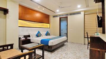 A hotel room with a bed, bedside tables, a desk, and a chair.