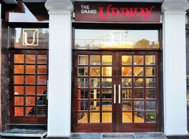 L'ingresso del Grand Uddhav, caratterizzato da un'ampia porta in legno e pannelli di vetro.