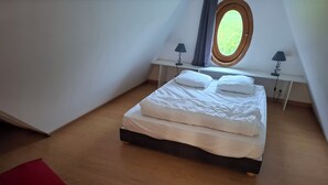 Una camera da letto con un letto, una finestra, un comodino e una lampada.