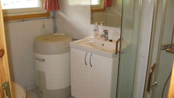 A compact bathroom with a toilet, a sink, and a shower.