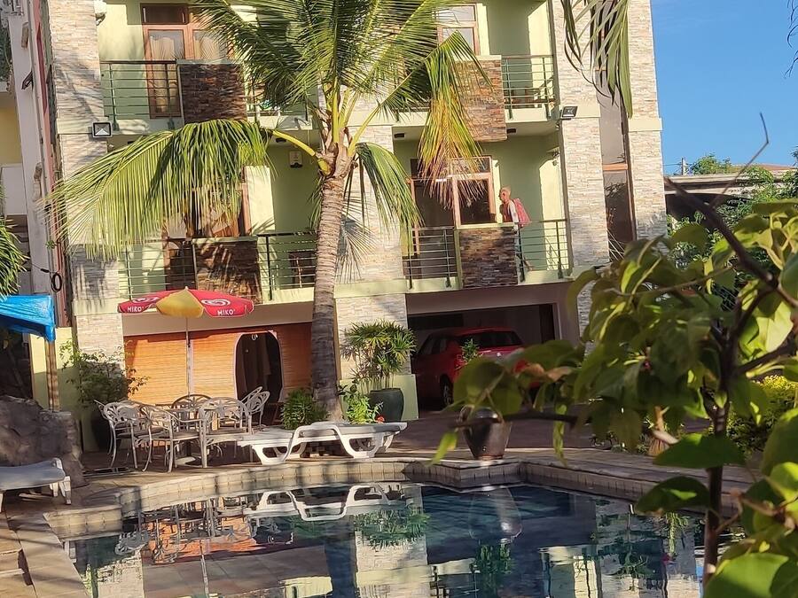 A modern building with balconies, a swimming pool, and outdoor furniture.
