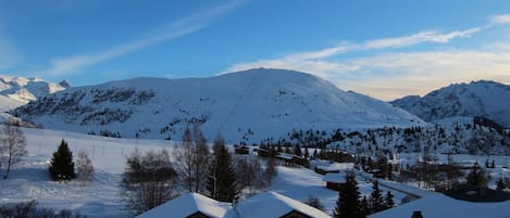 A snow-covered mountain landscape with wooden cabins.