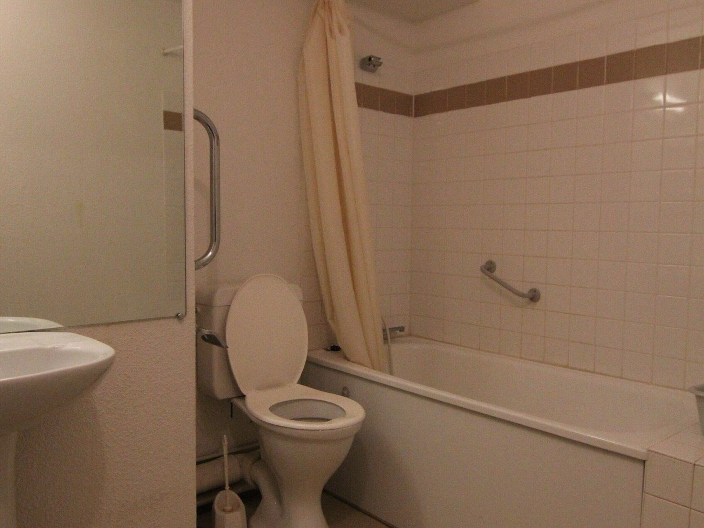 Een badkamer met toilet, wastafel en bad.