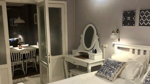 A bedroom with a bed, a bedside table with a mirror, a desk with a chair, and a wardrobe. - Mehmet Bey Suites (Istanbul)