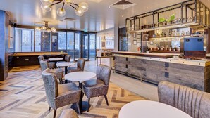 A modern bar area with seating and a bar counter. - hub by Premier Inn London Earl's Court (West Brompton) (London)