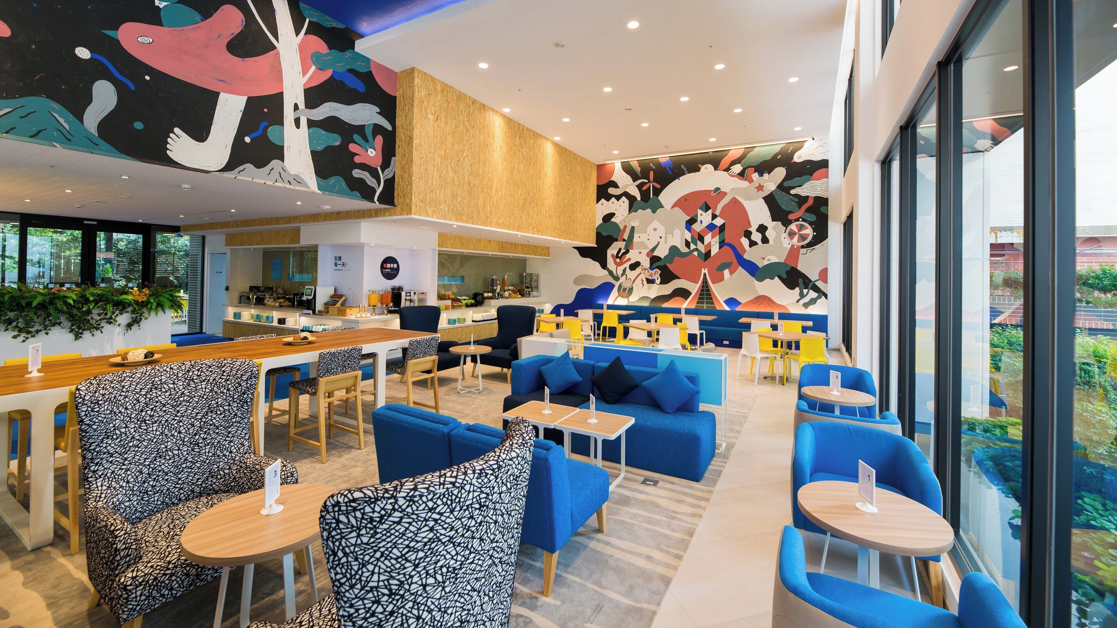 A modern cafe with a variety of seating options, including bar stools, sofas, and round tables.