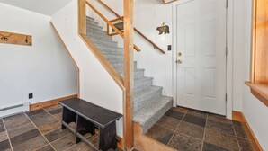 A staircase with wooden railings and a bench at the bottom. - 🐾Dallas Ridge - Dog friendly four seasons home in Rangeley! (Rangeley)