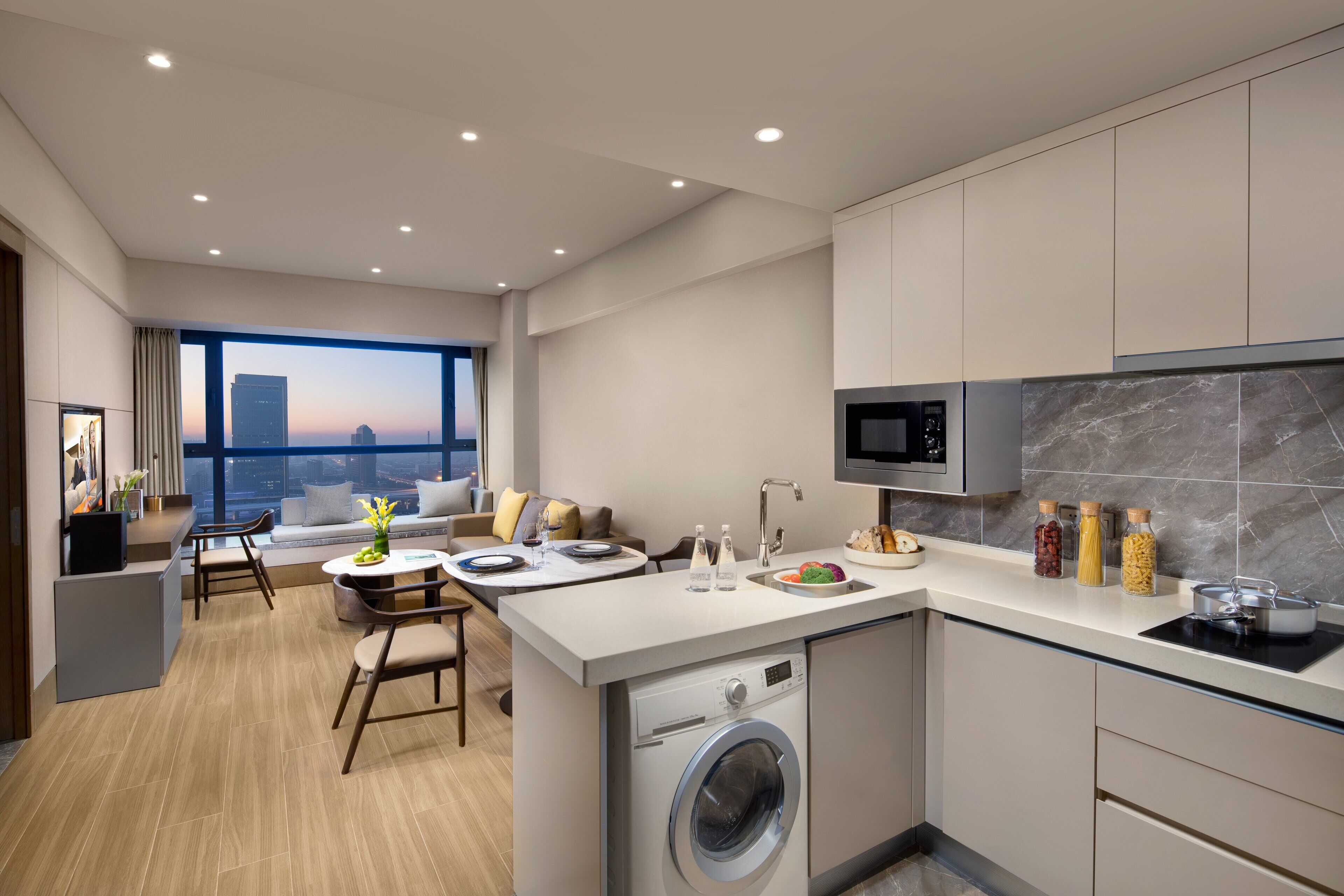 Una cocina moderna con lavadora integrada, un comedor con vistas y un amplio ventanal.