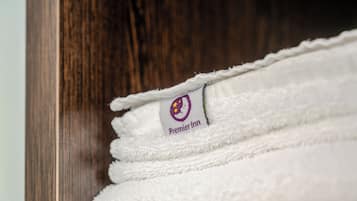 Uma pilha de toalhas brancas com o logotipo da Premier Inn.