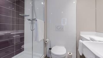 Une salle de bain moderne avec une douche à parois de verre, des toilettes et un lavabo avec une serviette.