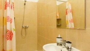 Un baño con bañera, lavabo y ducha.
