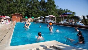 A swimming pool with people playing and relaxing. - Camping la Garenne (Peyrignac)