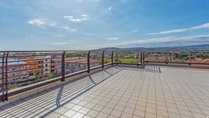 A rooftop terrace with a view of surrounding buildings and a clear sky. - Penthouse (Roseto degli Abruzzi)