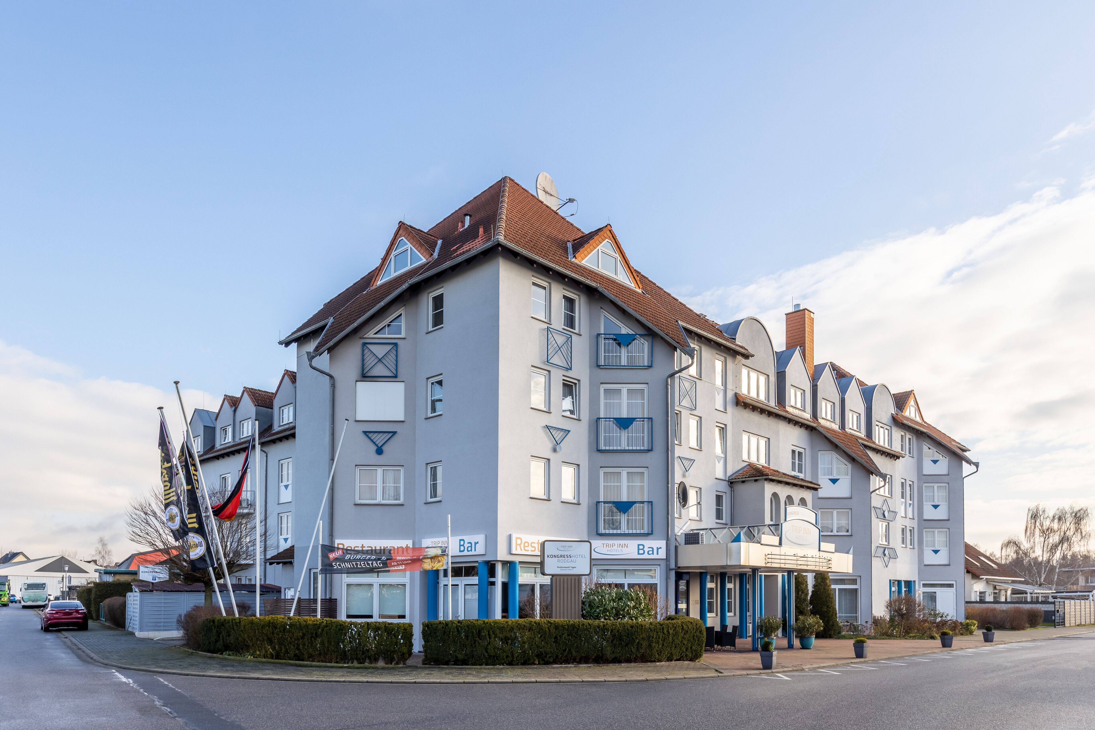 A multi-story hotel with a modern architectural design, featuring balconies, a rooftop terrace, and various amenities including a restaurant, bar, and conference rooms.