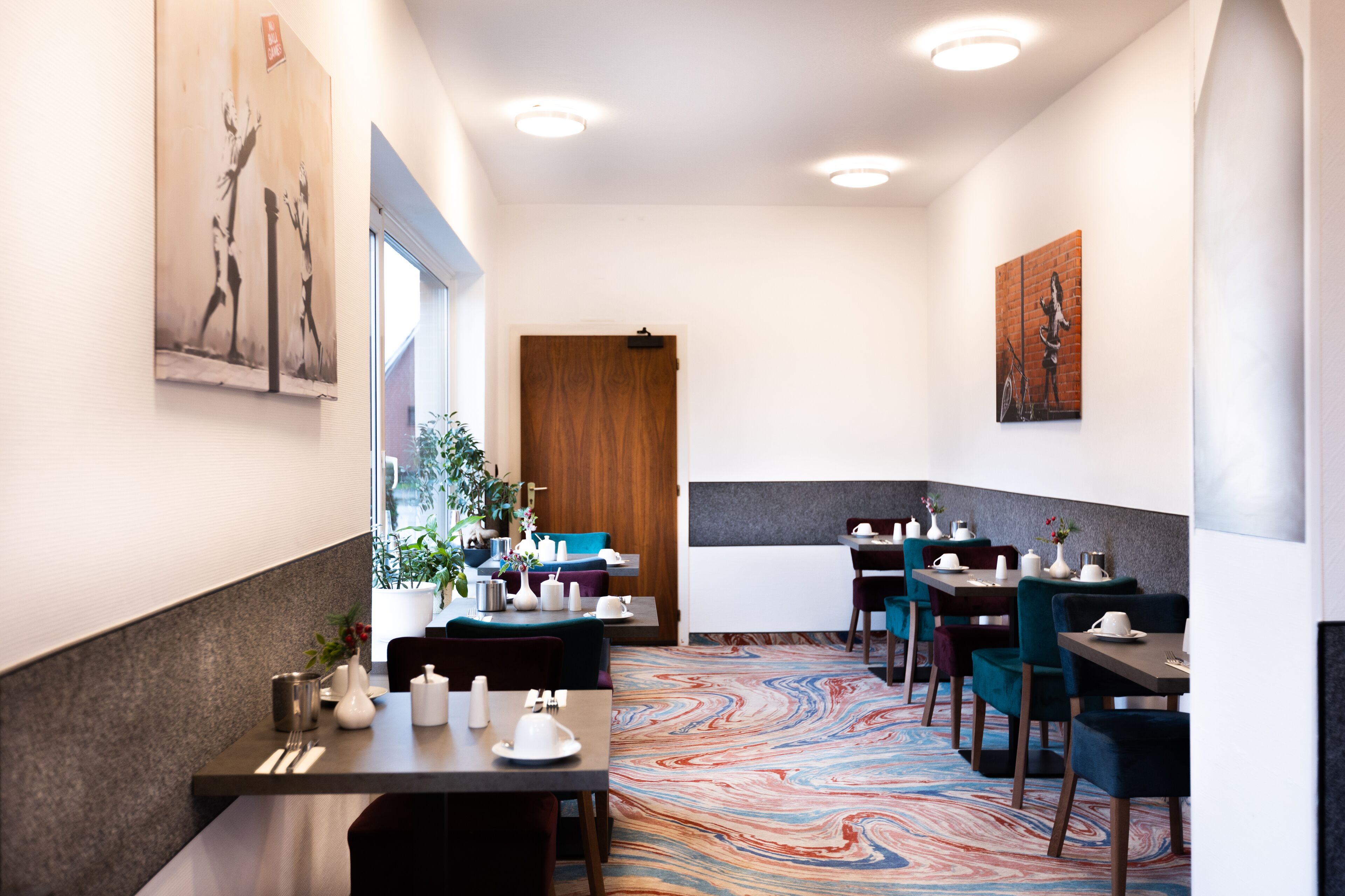 Un restaurante moderno con suelo de mármol, detalles de madera y obras de arte en las paredes.