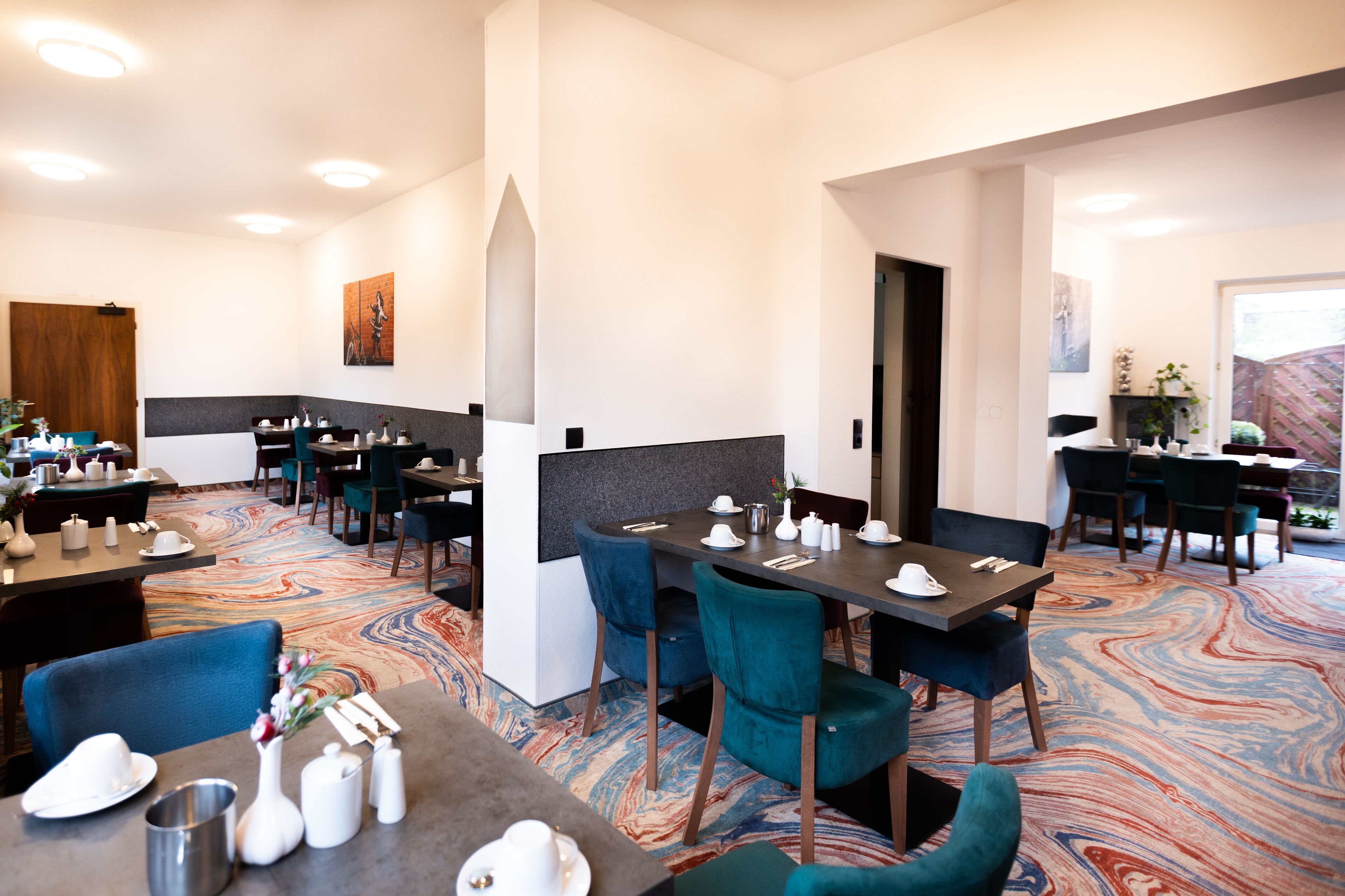 A restaurant with multiple tables and chairs, a marble-patterned floor, and a modern interior design.