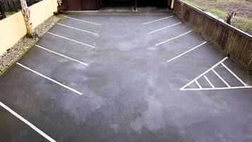 A parking lot with marked spaces and a building entrance.