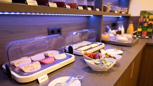 Una mesa de buffet con diversos alimentos y utensilios.
