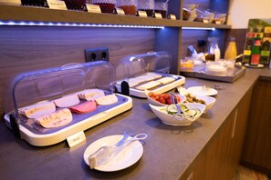 A buffet setup with various food items and utensils. - Firzlaffs Hotel Neumünster (Neumuenster)