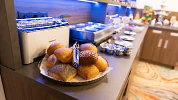 Ein Buffet mit verschiedenen Backwaren und einer Kaffeemaschine.